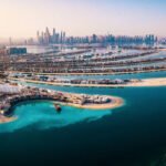 The Palm island panorama with Dubai marina rising in the background aerial view