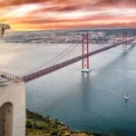 Composition photo of the Cristo Rei statue in front of April 25th Bridge at sunset, Almada, Lisboa Region, Portugal