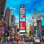 New York, USA - May 11, 2013: Times Square with tourists. Iconified as "The Crossroads of the World" it's the brightly illuminated hub of the Broadway Theater District.
