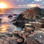 People visiting Giant s Causeway at the sunset in North Antrim, Northern Ireland